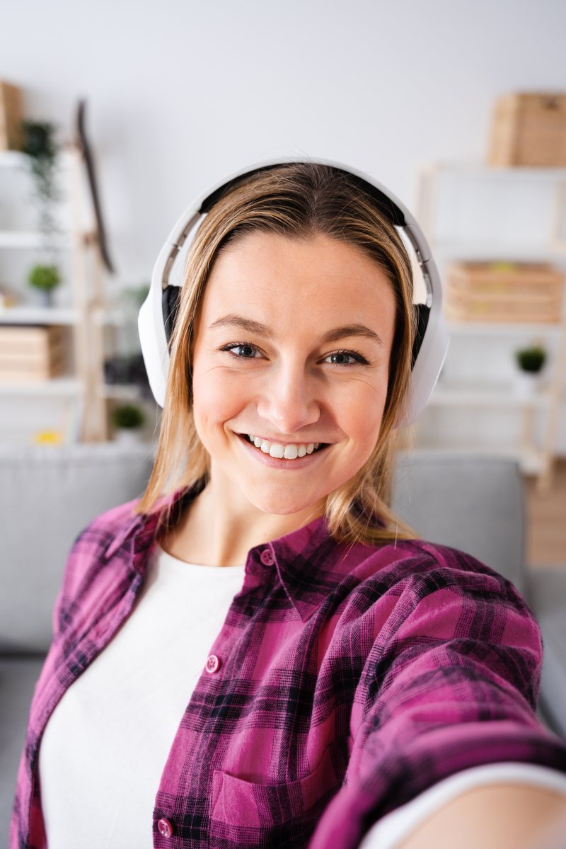 Creator in headphones recording a video at home with the script floating on screen